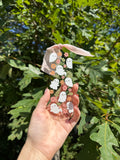 Floral ghosts acrylic bookmark with pink and peach flowers and blush ribbon held outdoors