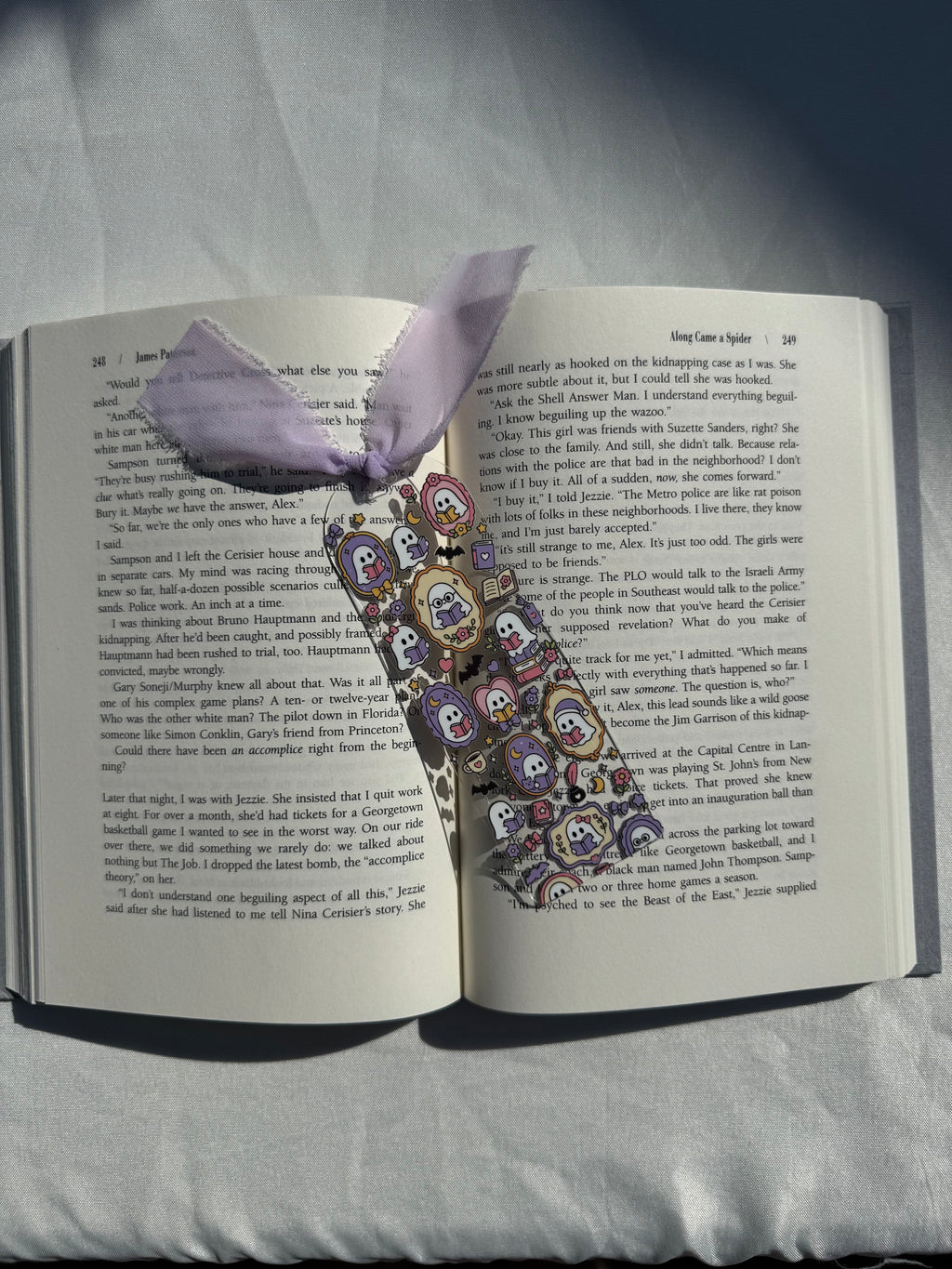 Bookish ghosts acrylic bookmark resting on an open book