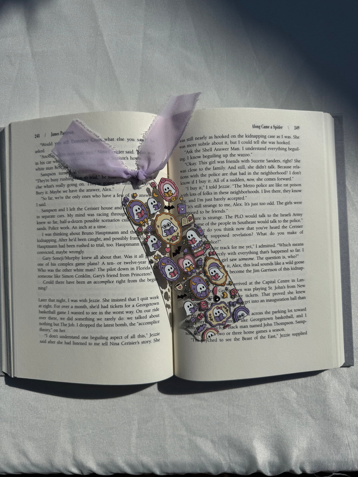 Bookish ghosts acrylic bookmark resting on an open book